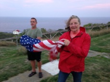 Candy and Bill fold the flag at sunset.